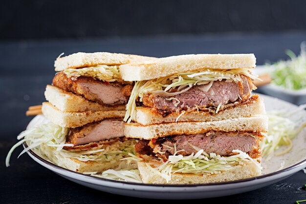 japanese sandwich with breaded pork chop, cabbage and tonkatsu sauce