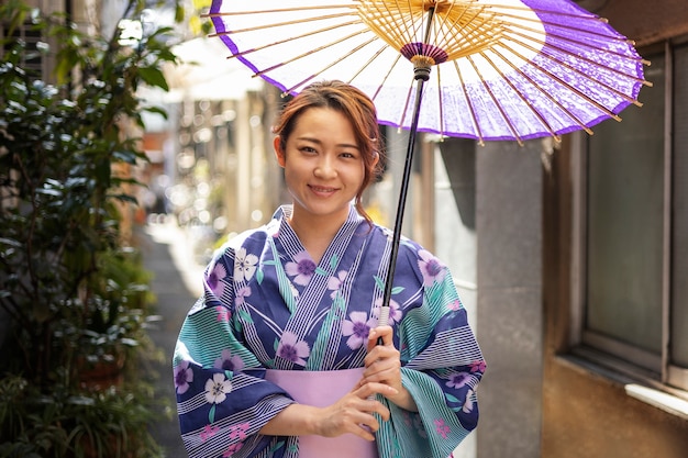 Foto gratuita ombrello giapponese wagasa aiutato da una giovane donna