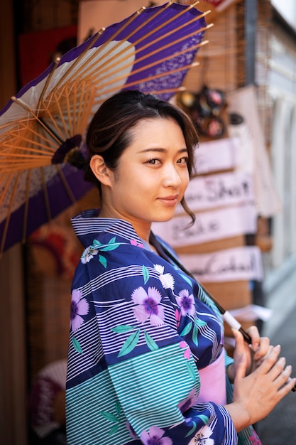 무료 사진 젊은 여성의 일본 와가사 우산 도움