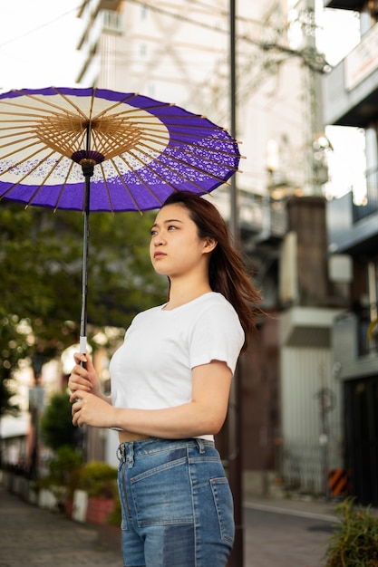 무료 사진 젊은 여성의 일본 와가사 우산 도움