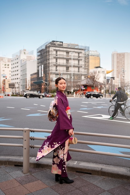 Free photo japanese woman celebrating coming of age day and posing in the city