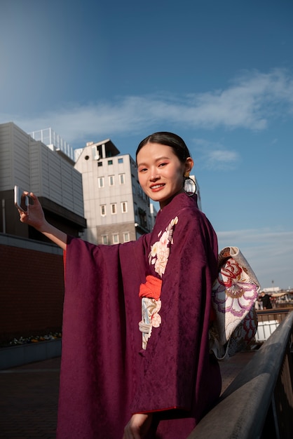 Free photo japanese woman celebrating coming of age day and posing in the city