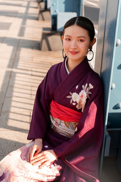 Foto gratuita donna giapponese che celebra il giorno della maggiore età e posa in città