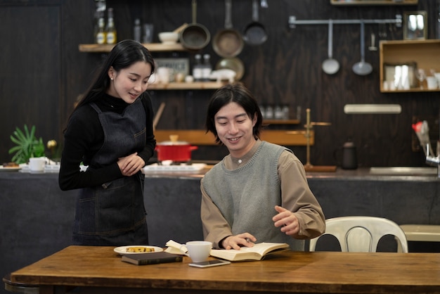 Японская женщина и мужчина читают из блокнота в ресторане