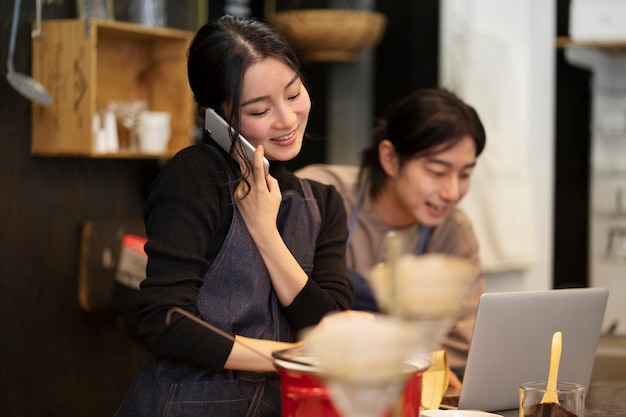 Free photo japanese woman talking on smartphone in a restaurant