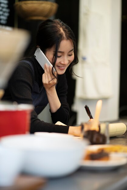レストランでスマートフォンで話している日本人女性