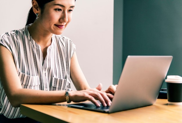 Donna giapponese che lavora su un computer portatile