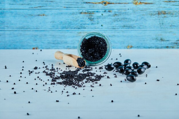 A jar of caviar on a blue background.