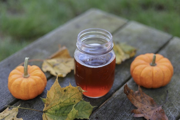 Free photo jar of honey beside two pumpkins