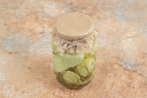 Foto gratuita un vasetto di verdure sottaceto sulla superficie in marmo
