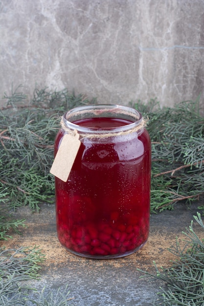 Un barattolo di succo rosso su fondo marmo. foto di alta qualità