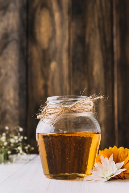 Jar of sweet honey and flowers on desk