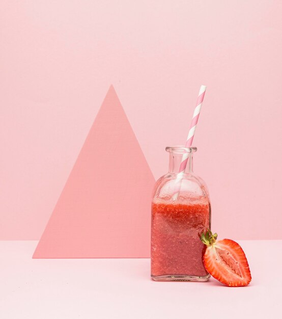 Jar with fresh smoothie of strawberry on desk