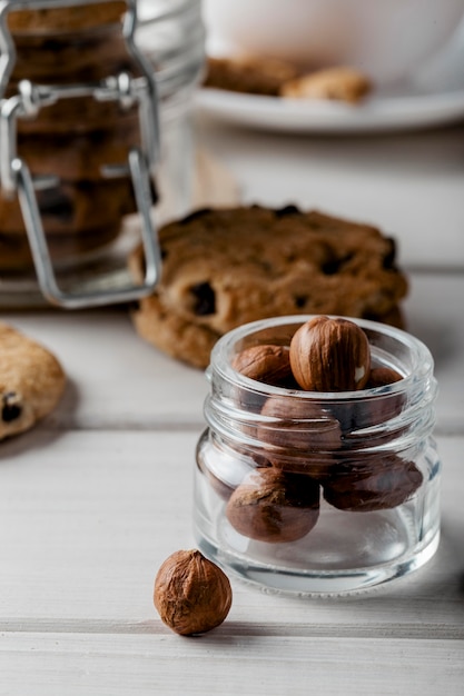 Foto gratuita vaso con noci e biscotti deliziosi sul tavolo