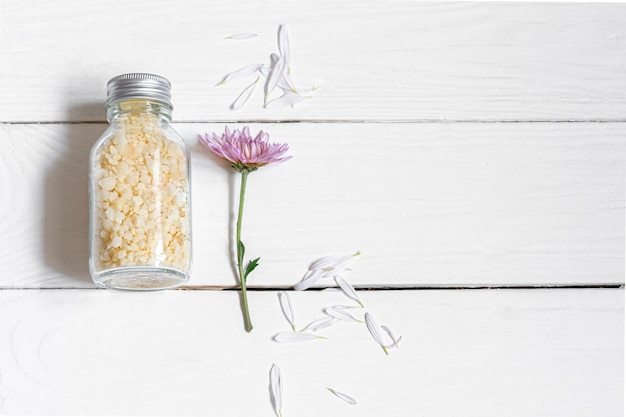 Jar with sea salt on a white wooden background