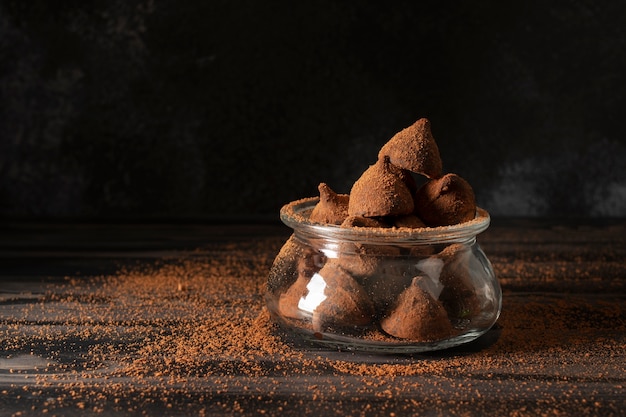 Jar with truffles on wooden table