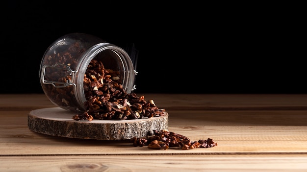 Jar with walnuts on wooden board