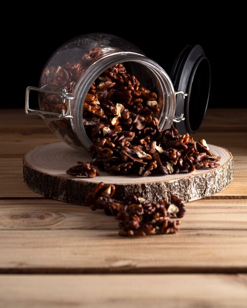 Jar with walnuts on wooden board