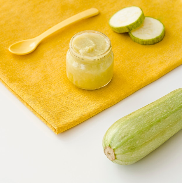 Jar with zucchini puree on desk