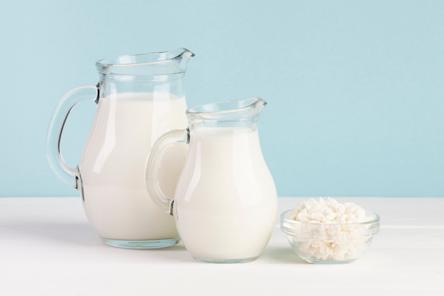 Jars filled with milk on blue background