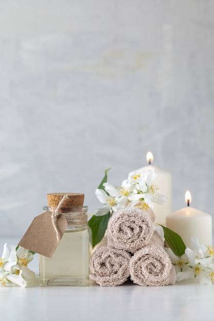 Free photo jasmine essential oil, candles and towels, flowers