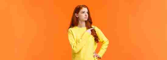 Free photo jealous or envy sad sulking redhead girl in yellow sweater looking at desired thing shoppaholic cant