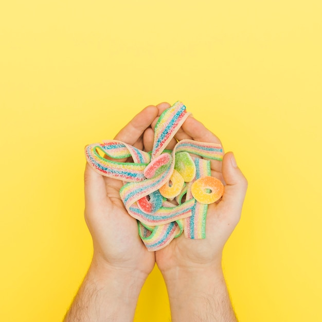 Free photo jellies in palms on yellow background