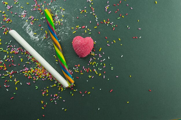 Jelly heart near candy sticks