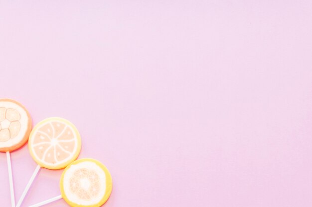 Jelly sugar lollipops on the corner of pink background