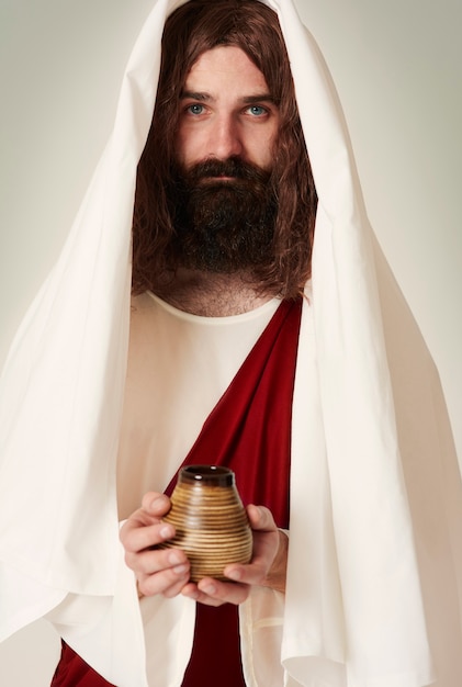 Иисус в халате держит святую воду на кувшине