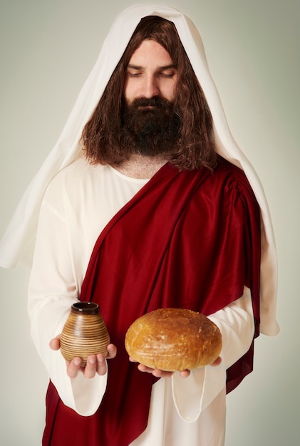 Jesus with eyes closed holding wine and bread