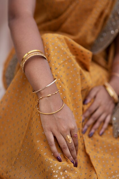 Детали драгоценностей на руках женщины в платье сари