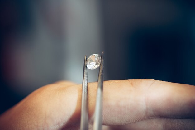 Jeweler holding diamond with  tweezers