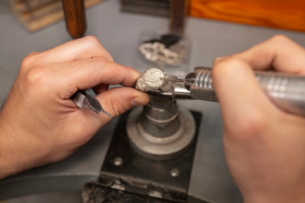 Free photo jeweler's hands making jewellery