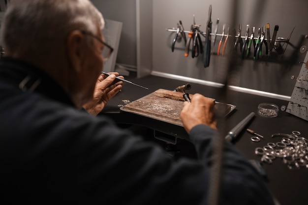 Free photo jeweler working in the shop with equipment