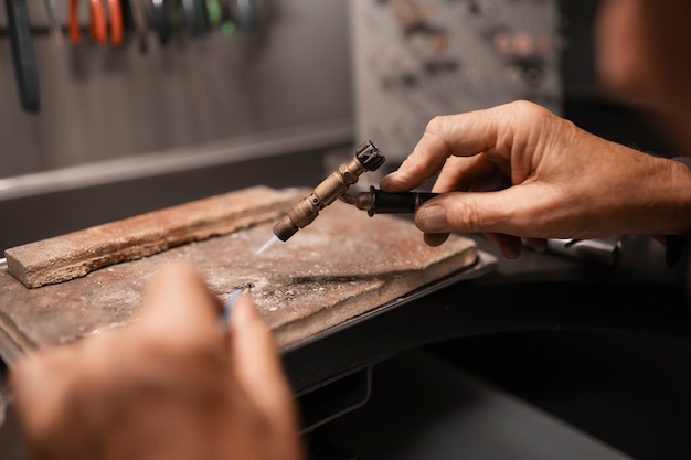 Free photo jeweler working in the shop with equipment