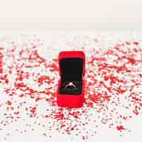 Free photo jewellery box with ring near confetti