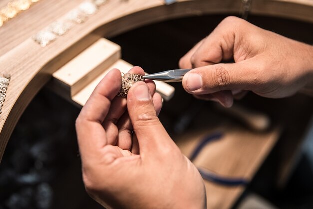 Jewelry maker creating a golden piece