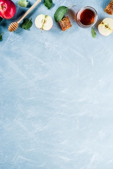 Еврейский праздник рош ха-шана или концепция яблочного праздника, с красными яблоками, яблочными листьями и медом в банке, голубая фоновая копия сверху