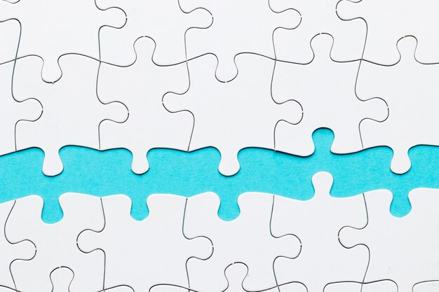 Jigsaw puzzle piece against on blue backdrop