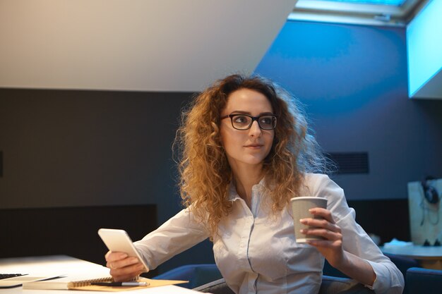 Job, business and occupation concept. Beautiful curly haired young woman secretary multitasking