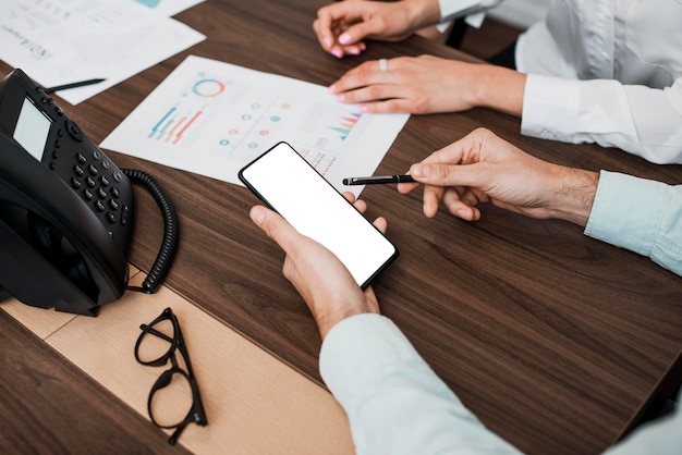 Job colleagues working on mobile phone and graphs