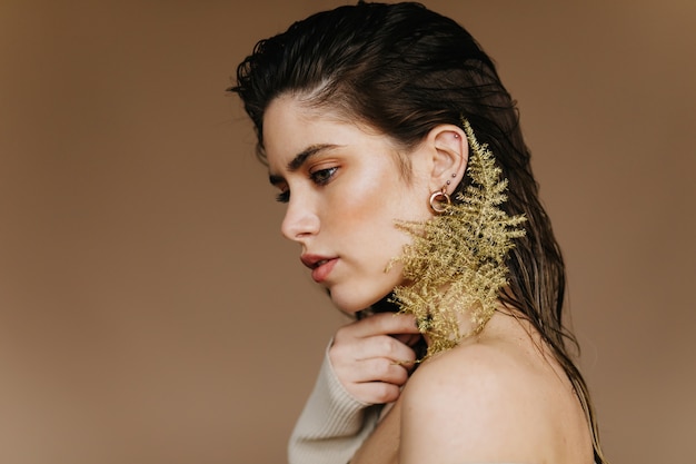 Jocund brunette woman posing with calm face expression.  joyful white girl with plant.