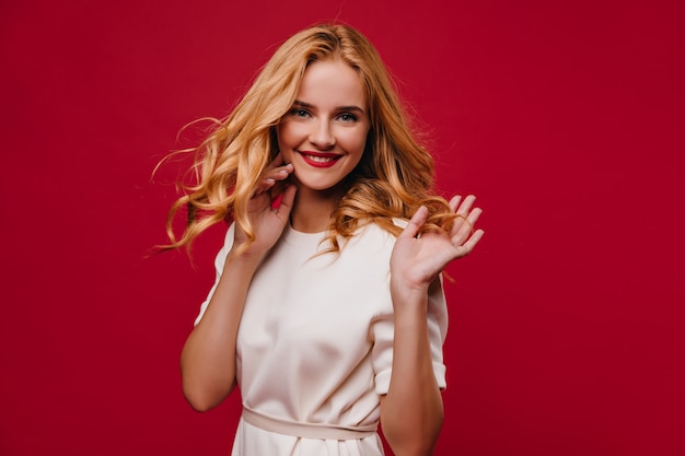 Jocund girl with long hairstyle enjoying life. Laughing dreamy woman posing with happy smile.