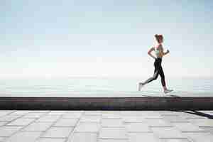 Free photo jogging young woman running on shore