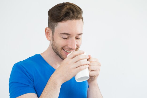 Jolly handsome man smelling coffee