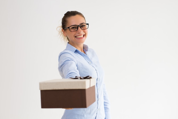 Jolly smiling girl in glasses giving present