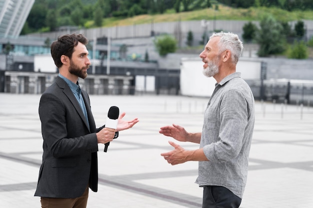 Journalist taking an interview from a man