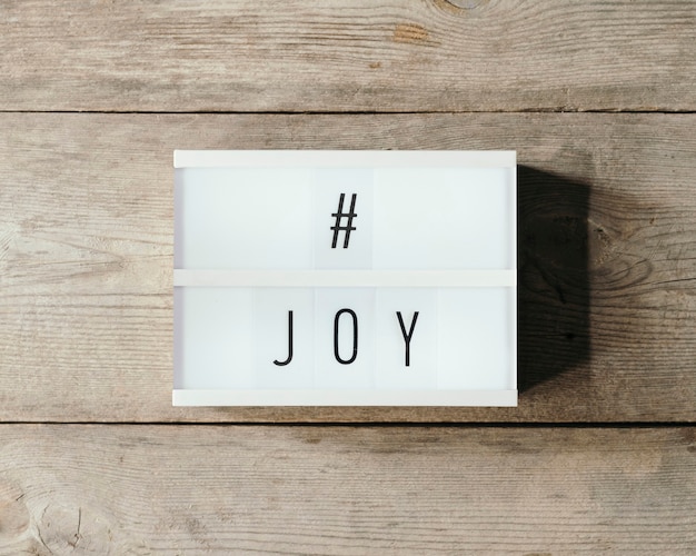 Joy text over a led panel and wooden background