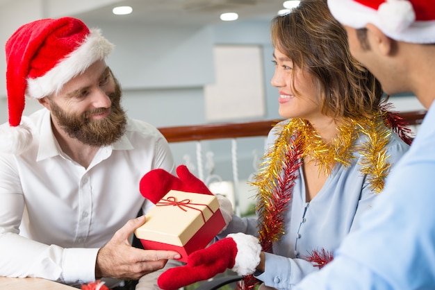 Радостные коллеги по бизнесу обмениваются подарками